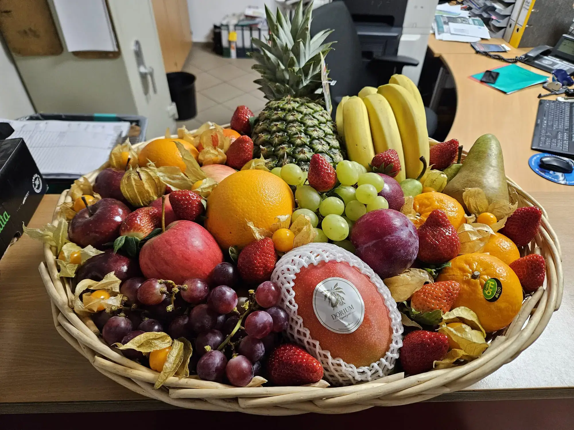 Frischer Obstkorb mit Ananas, Erdbeeren und Trauben